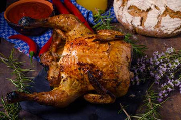 Beer can chicken grilling upright on a barbecue