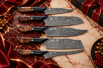 Set of five premium Damascus kitchen knives with wood and black handles displayed on burgundy and cream marble with luxurious gold accents, ideal for custom corporate gift collections.