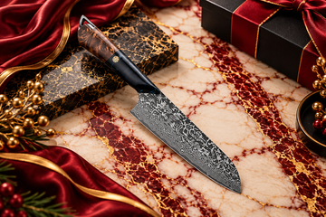 Alt text: Premium Damascus chef knife with a wood and black handle displayed on burgundy and white marble with elegant gold accents for corporate gift presentation.
